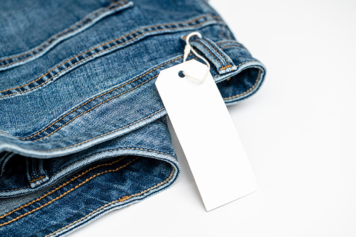 Denim jeans and blank clothing tag. Template for tag or label design