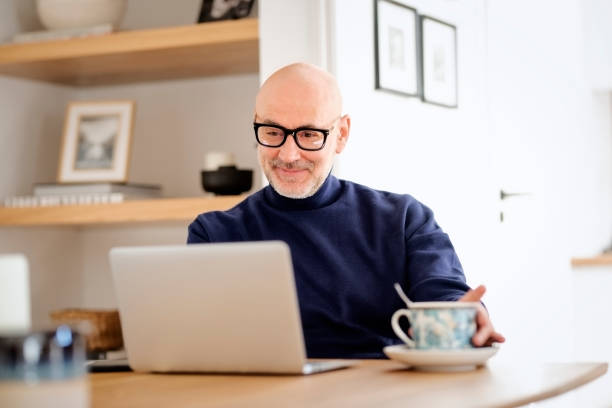 istock Middle aged businessman wearing casual clothes and using laptop while working from home 1934535886