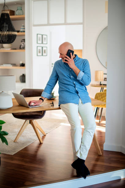 istock Middle aged businessman using smartphone and laptop while working from home 1934545447