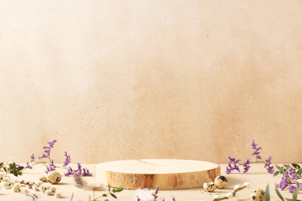 istock Empty round wooden podium, quail eggs with spring flowers on a beige background. Front view 1934547150
