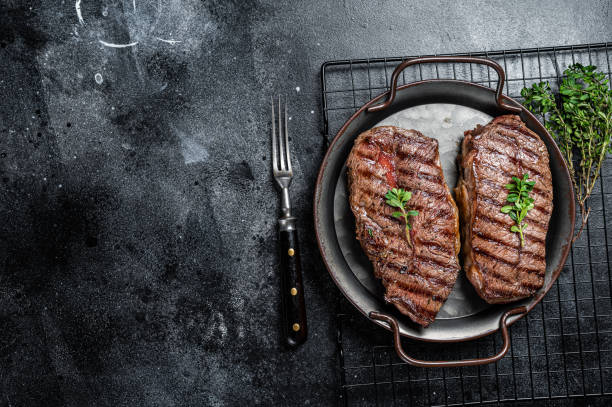 istock Grilled Top Blade or flat iron beef meat steaks. Black background. Top View. Copy space 1934559237