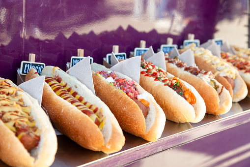 Fresh Hot dogs  with sauce displayed in a row on food truck