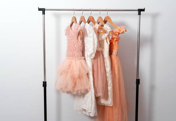 istock Puffy dresses hang on hanger on clothes rail on white wall background 1934573852