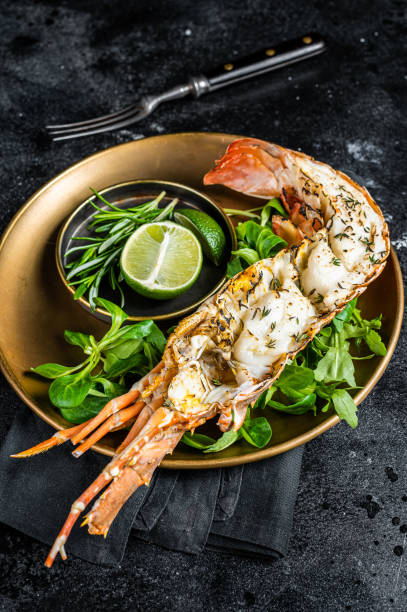 istock Grilled Spiny lobster with salad on a plate. Black background. Top view 1934590477