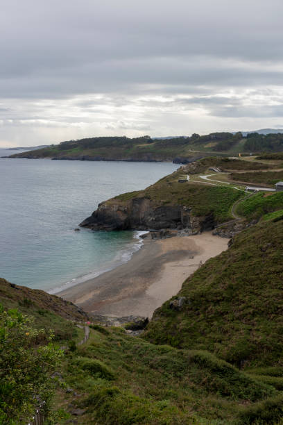 istock a scenic view of a secluded beach, surrounded by greenery and cliffs, under a cloudy sky 1934592109