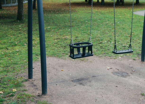 Empty park playground with swing in a city park