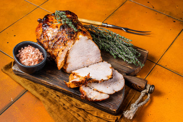istock Roasted Pork Meat Roll with garlic sliced on cutting board. Orange background. Top view 1934613762