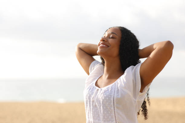 istock Joyful black woman breathing on the beach 1934618565