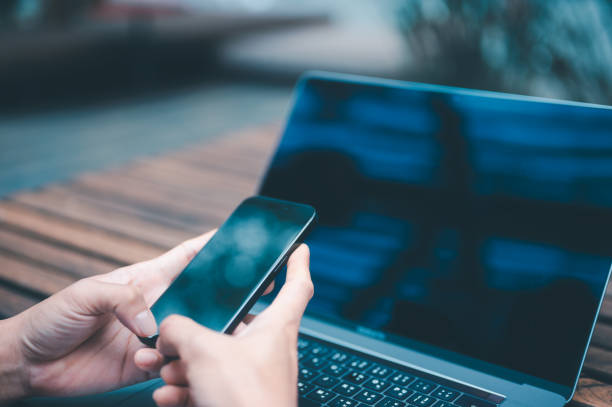 istock a businessman or freelancer using computer laptop and smartphone sitting on table outside working on business or internet online marketing 1934619626