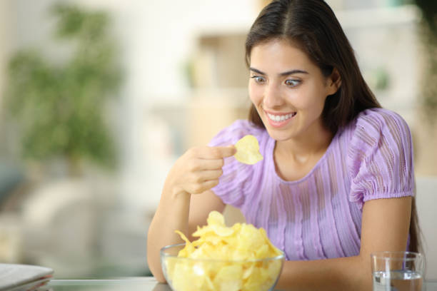 istock Glutton woman eating potato chips eagerly 1934622304