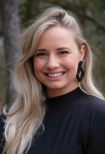 Blond woman with a smile, headshot. Black earring and black top. A happy smile and open eyes.