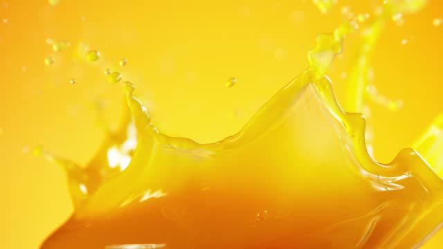 Super slow motion of splashing orange juice.