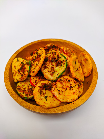 Kerupuk seblak or seblak crackers in a wooden bowl. Seblak crackers are a snack with a spicy taste originating from West Java. The characteristic of these crackers is that they are sprinkled with chil