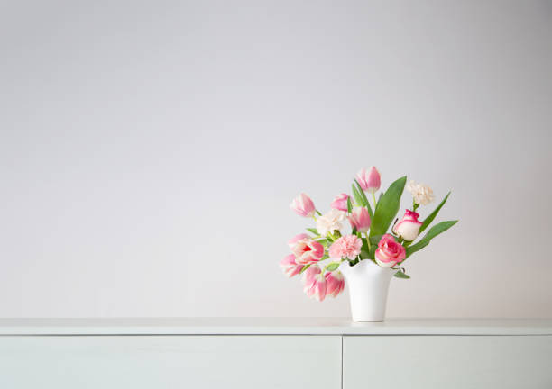 istock pink spring flowers in white ceramic vase in modern home interior 1934682698