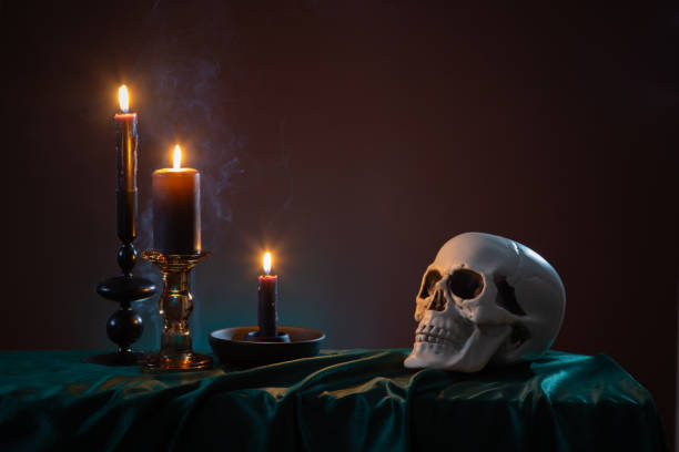 istock scull and burning candles with halloween decor on dark background 1934682707