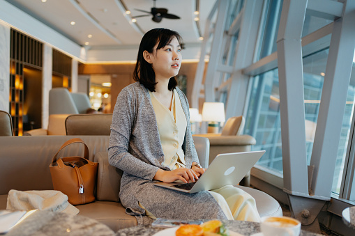 An Asian Chinese businesswoman working in airport lounge