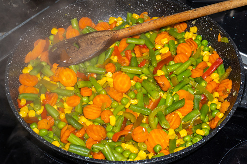 Steaming mixed vegetables in the pan cooking vegetarian and healthy