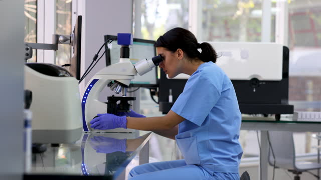Female researcher working at the laboratory using a microscope