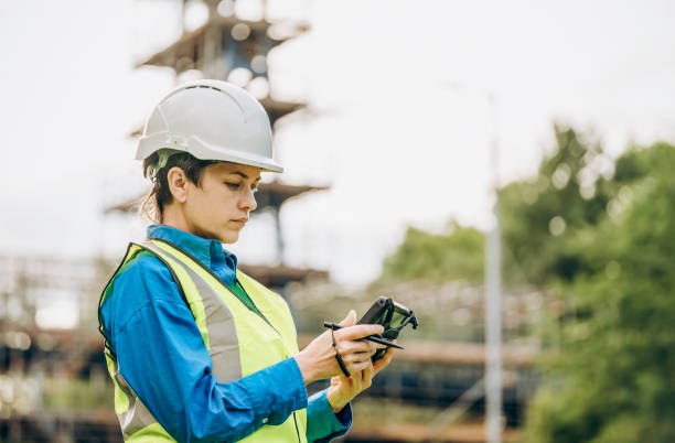 female site engineer surveyor working with theodolite total station edm equipment on a building construction site outdoors - people in a row in a row business office worker zdjęcia i obrazy z banku zdjęć