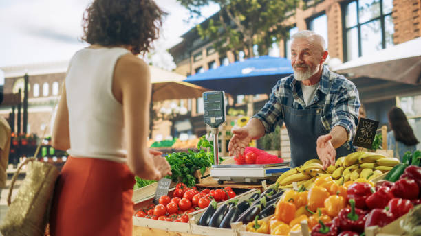 istock Young Beautiful Customer Shopping for Fresh Natural Vegetables for a Mediterranean Dinner. Black Female Buying Bio Tomatoes and Ecological Local Garlic From a Happy Senior Street Vendor 1934737154