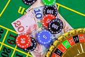 On green gaming table there are roulette, Georgian banknotes in of lari poker chips.