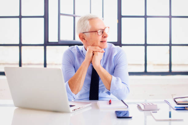 istock Senior businessman sitting at office desk and working 1934747833