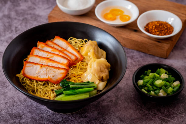 istock Egg noodle with red roasted pork and wonton in black bowl 1934755431