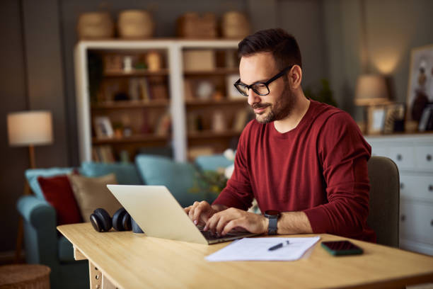 istock A focused male content creator typing on his laptop while working from home. 1934784038