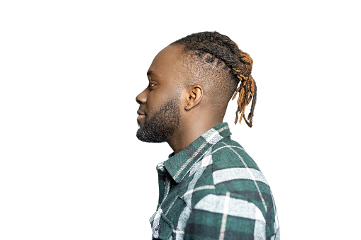 Profile portrait of African American man with beard and braided hair in studio. Side view of a young man against white background.