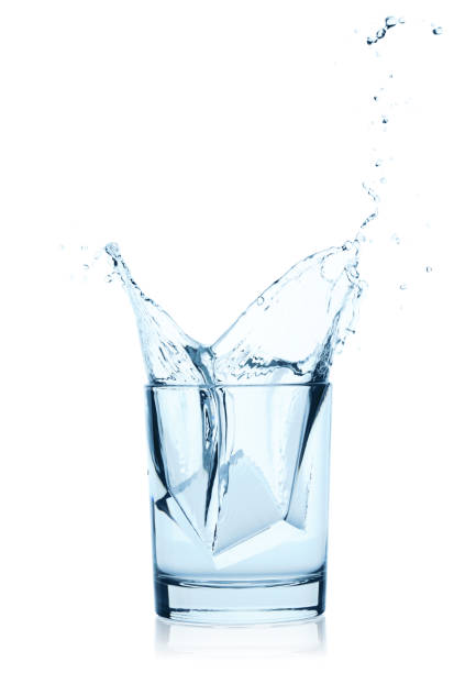 Falling Ice Cubes into the Glass of Water with splash, isolated on a white background