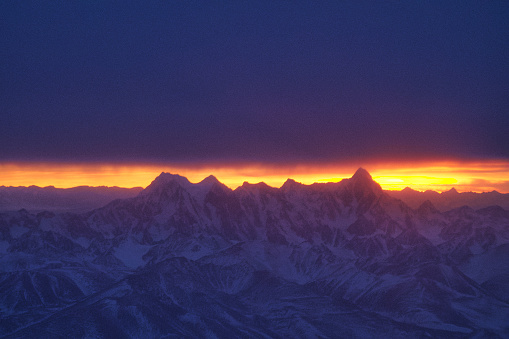 飛往中國新疆烏魯木齊的航班，降落時正巧碰上日落時分，當天烏雲密佈，與地面連綿的天山山脈相互壓迫，只留下遠處天邊的一線晚霞