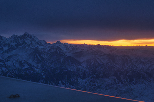 飛往中國新疆烏魯木齊的航班，降落時正巧碰上日落時分，當天烏雲密佈，與地面連綿的天山山脈相互壓迫，只留下遠處天邊的一線晚霞
