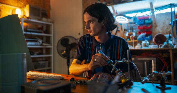 istock Portrait Of Caucasian Male Software Engineer Programming on Old Desktop Computer In Retro Garage In The Evening. Man Starting Tech Startup Company In Nineties. Coding Innovative Online Service At Home 1934838051