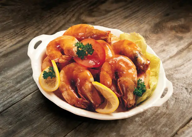 Photo of Stir fried shrimps with soy sauce on a plate with vegetables