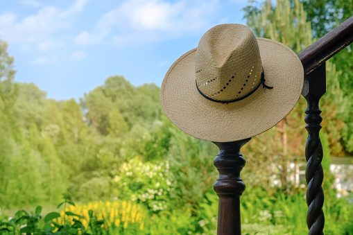 Straw Hat hanging in the green garden. Selective focus