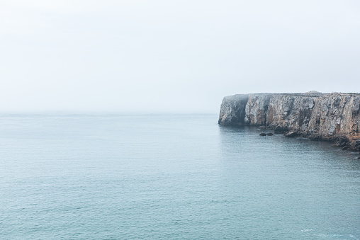 Dramatic cliffs in fog at Atlantic Ocean, Sagres, Algarve, Portugal
