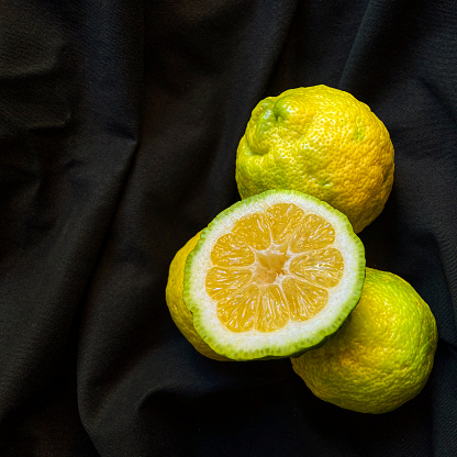 High angle view  of lemon cut in half over black fabric.Image made in studio with natural light from window.