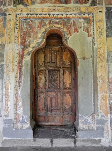 Permet, Albania-April 17, 2019: Saint Mary's Church of Leusa dates from the 18th century, built on older Byzantine-era remains. Carved wood door, highly vandalized murals from 1812 with Bible scenes.