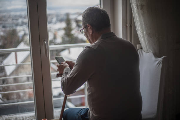 istock An elderly man is alone at home, using a smartphone 1934911650