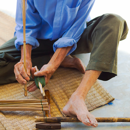 Close up hands weaving bamboo steamer in northeastern village of Thailand