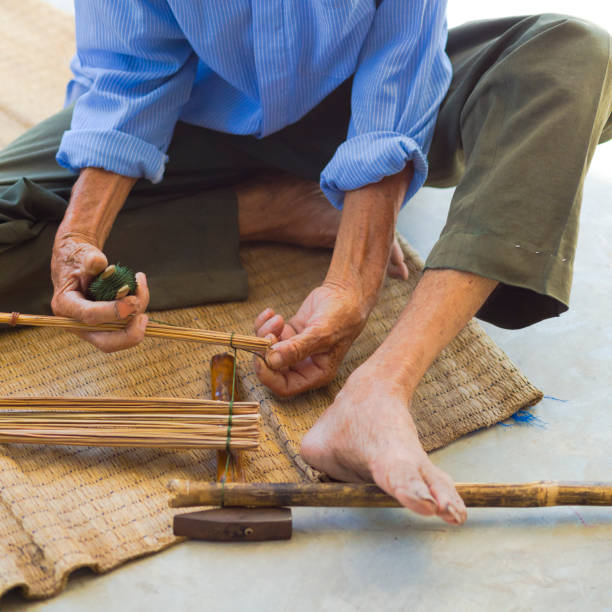 istock Thai senior man sitting on floor is doing craft work with bamboo 1934915987