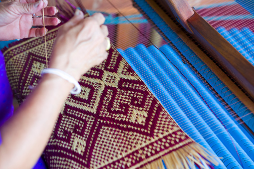 Close-up of thai loom and mature's woman hands