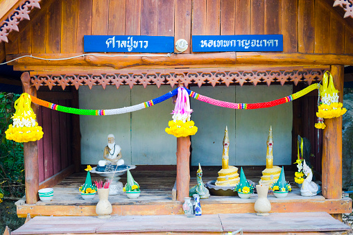 Small thai buddhist shrine with Brahma and nakhin snake statues. Shrine is on ground of local rural temple in village Paranghmee in province of Phitsanulok
