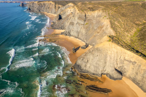 istock Sandy beach and dramatic cliffs on Atlantic Ocean coastline in Portugal. Aerial drone view 1934925622