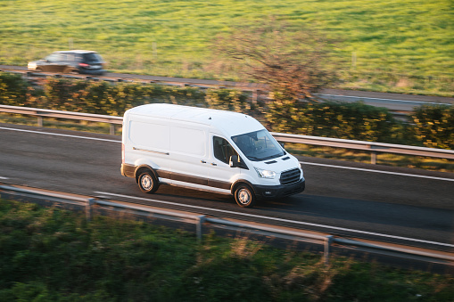 A delivery van in motion on a highway
