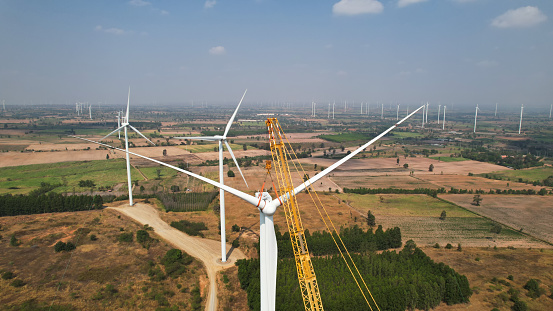 The blade of the wind turbine operates by  crane to install the engine of a wind turbine tower to generate green energy and reduce global warming and climate change