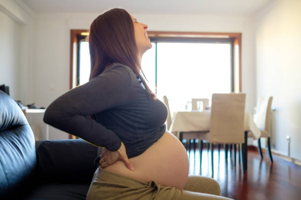 istock Pregnant woman on sofa with back pain 1934993565