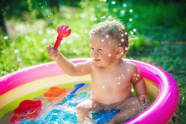 счастливый очаровательный мальчик плещется в красочном надувном бассейне - swimming pool one baby boy only toddler image type стоковые фото и изображения