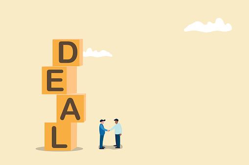 Business deal or financial agreement concept. Business negotiation, deal making or acquisition, merger. Two men shaking hands with deal text.