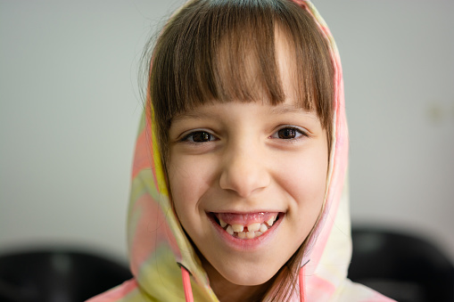 Smiling girl wearing hooded shirt and looking at camera